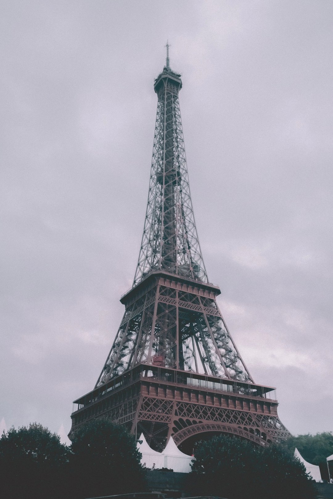 The Eiffel Tower stands tall against a cloudy sky in Paris.