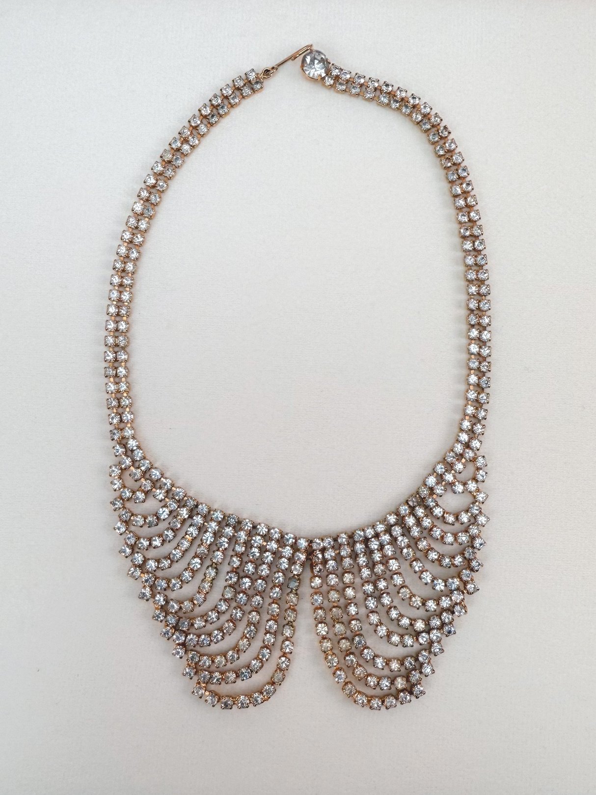 Gold 1970s collar necklace adorned with sparkling crystals in a cascading design.