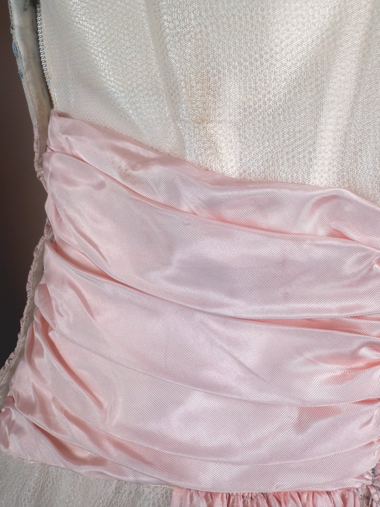 Silver 1950s women's dress featuring a ruched pink satin waist detail.