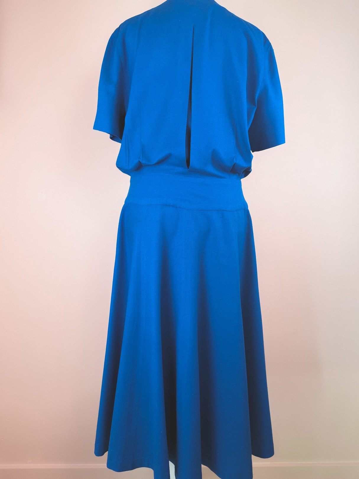 Cerulean blue women's dress from the 1980s featuring a relaxed fit and a knee-length skirt.