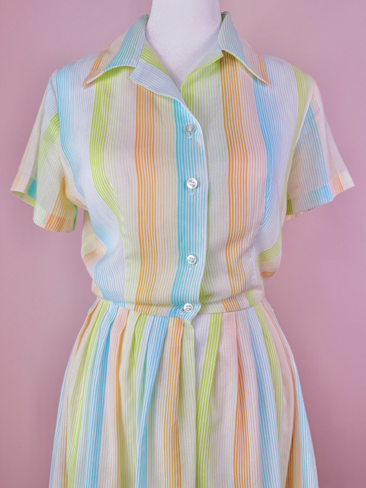 1950s women's Citrus Dress featuring a short-sleeve button-up bodice and a full skirt design in orange, blue, and green stripes.
