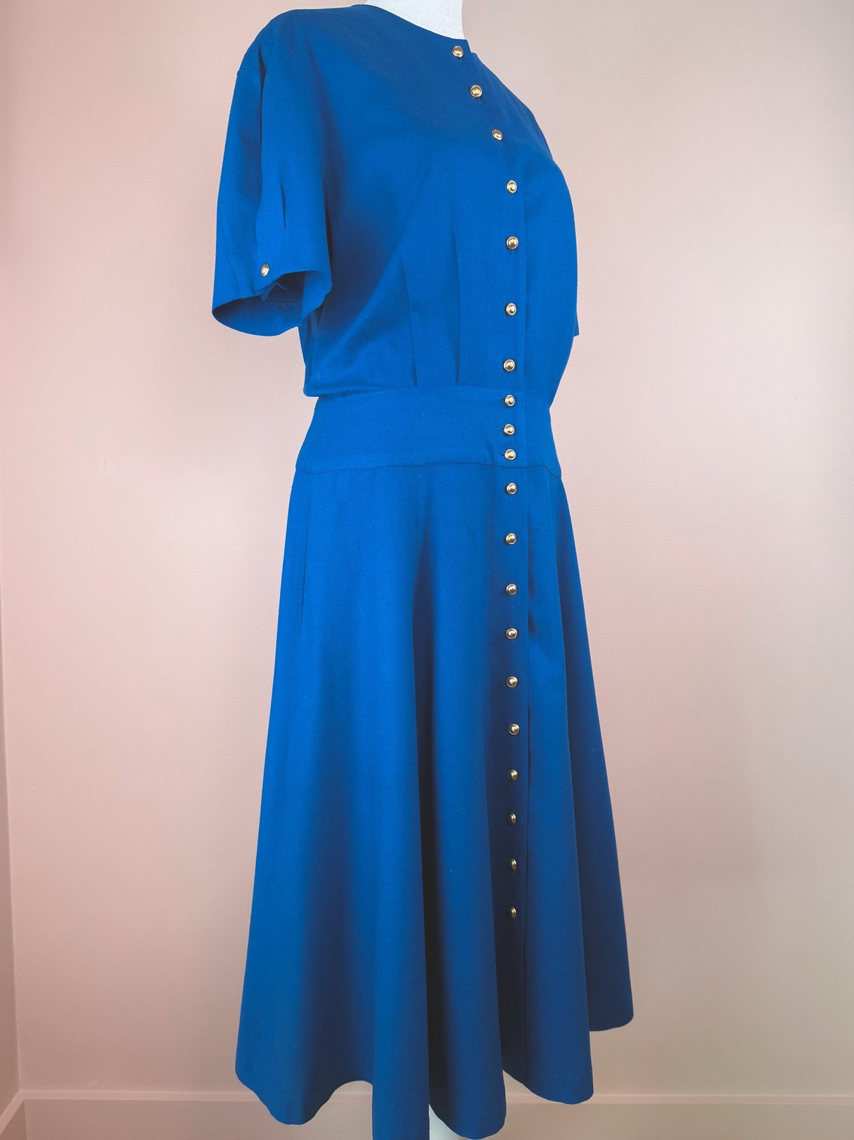 Cerulean blue 1980s women's dress featuring short sleeves and a button-down front.