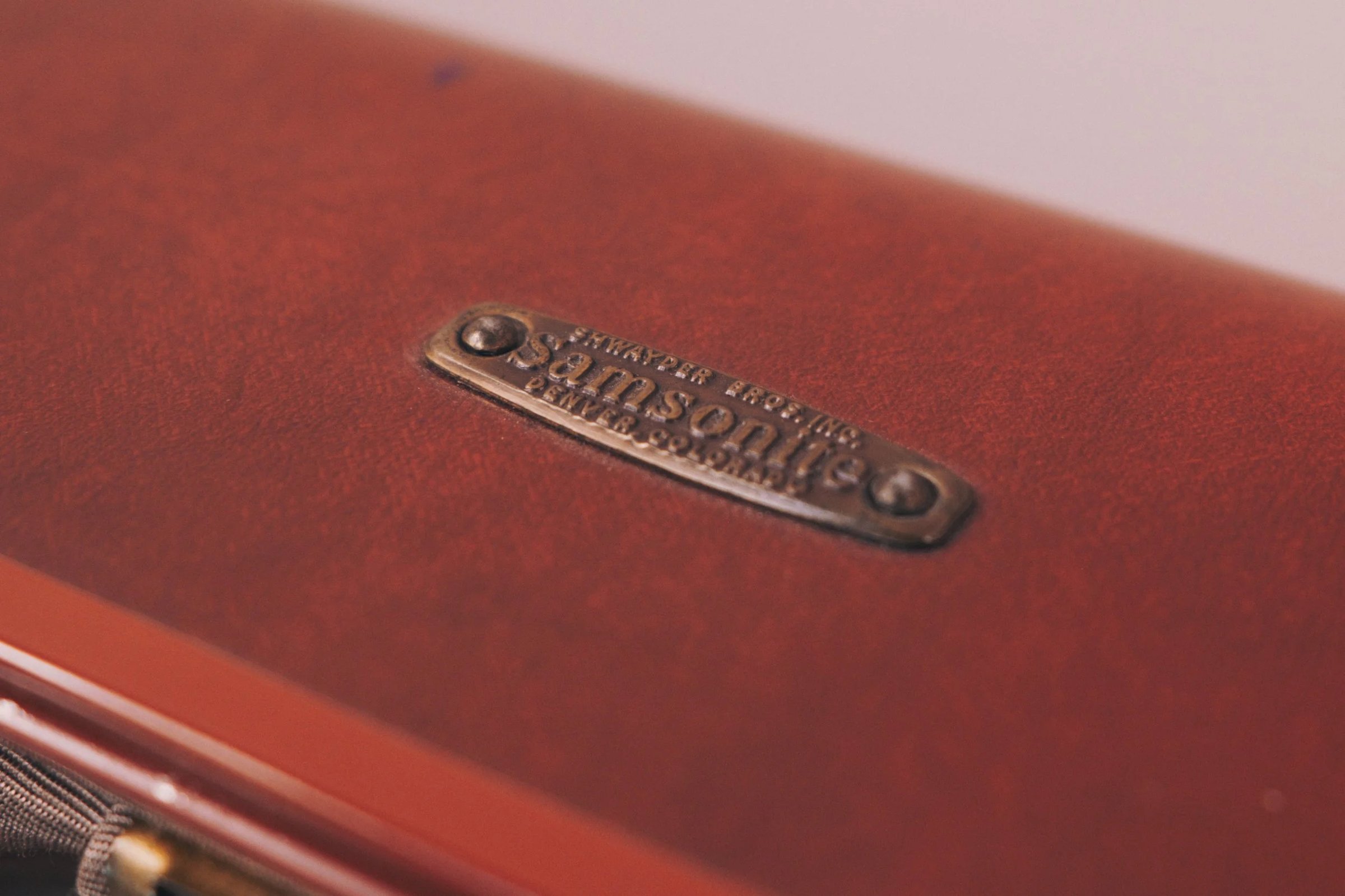 Close-up of a Samsonite brand label on a red textured surface.