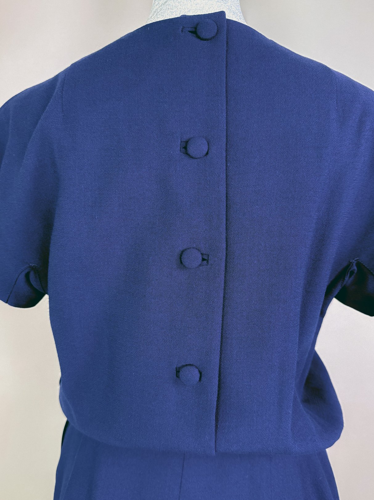 Navy blue women's dress set from the 1960s featuring three buttons along the back.