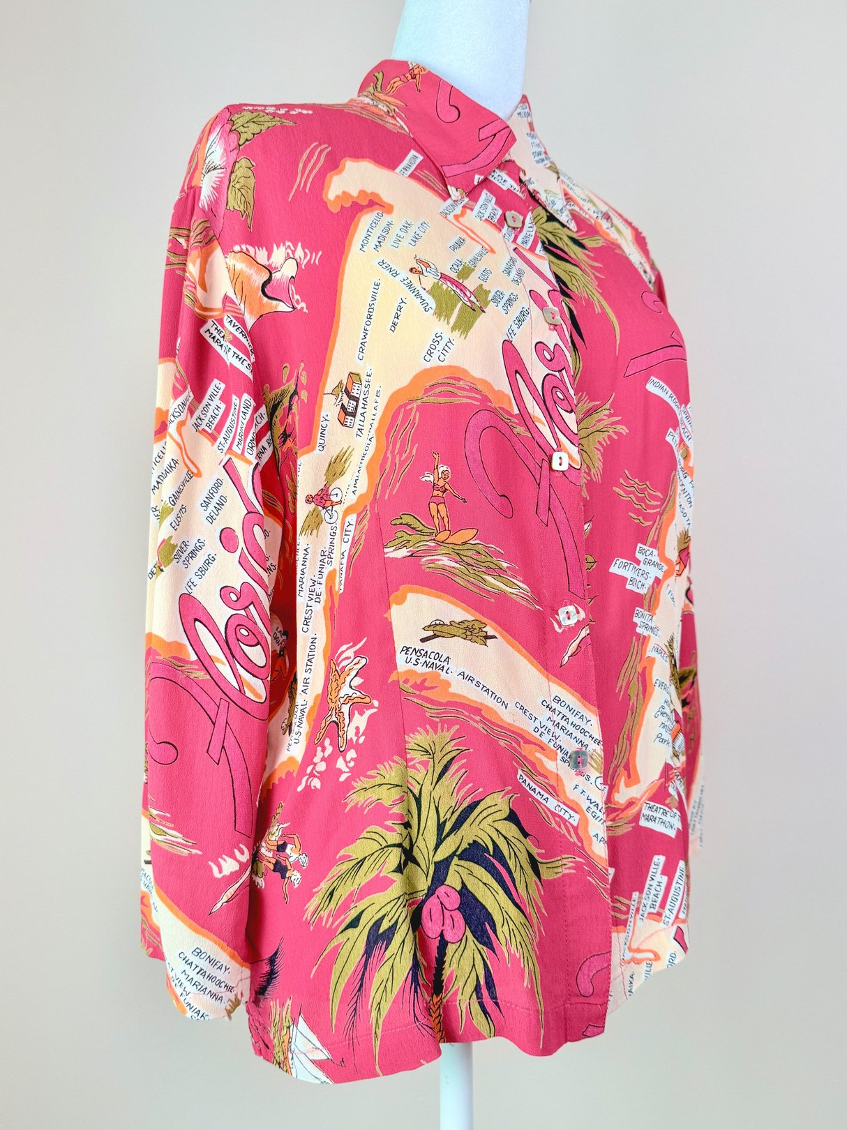 White blouse featuring a colorful 1970s Florida print with palm trees and maps.