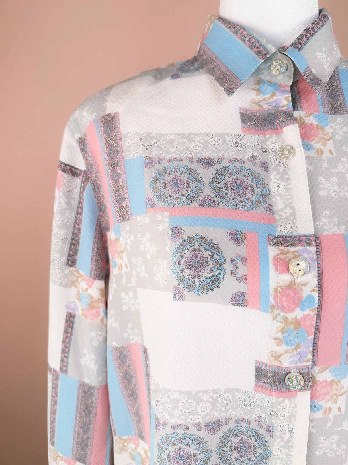 Close-up of a patterned shirt featuring pastel colors and intricate designs.