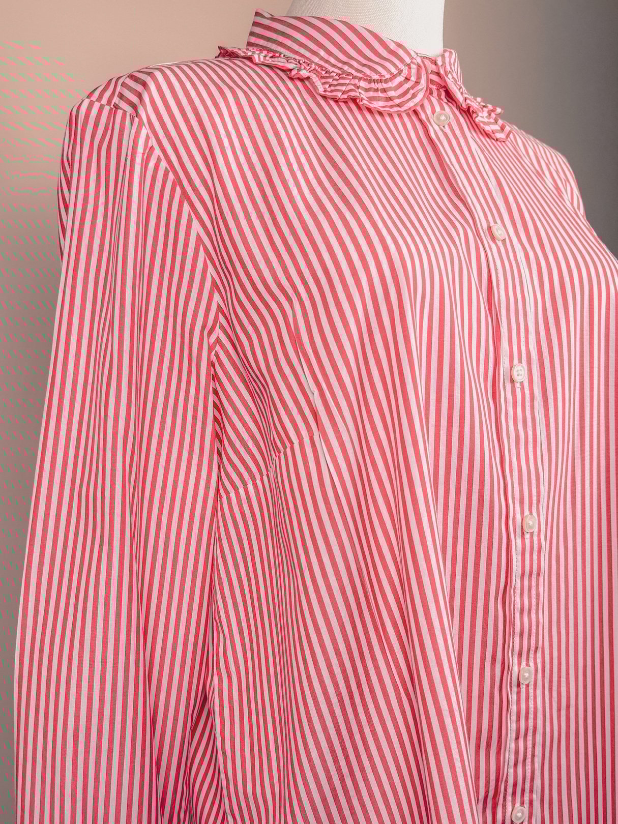 A red and white striped button-down top for women, featuring a collar and long sleeves, styled in a 1970s silhouette.