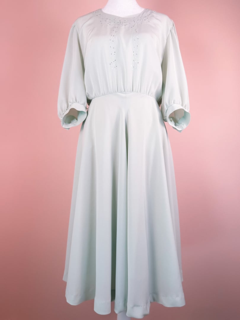 Mint green 1980s women's dress featuring a shimmer finish, balloon sleeves, and a flowy skirt.