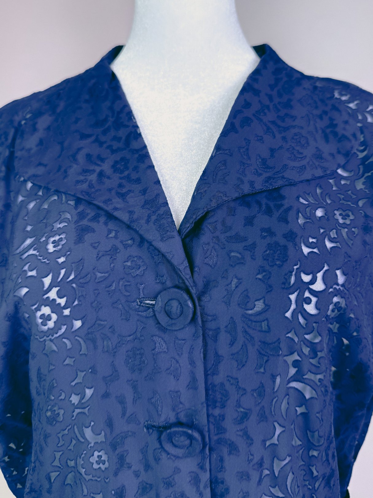 Navy blue 1940s women's dress featuring a floral pattern and button-front closure.