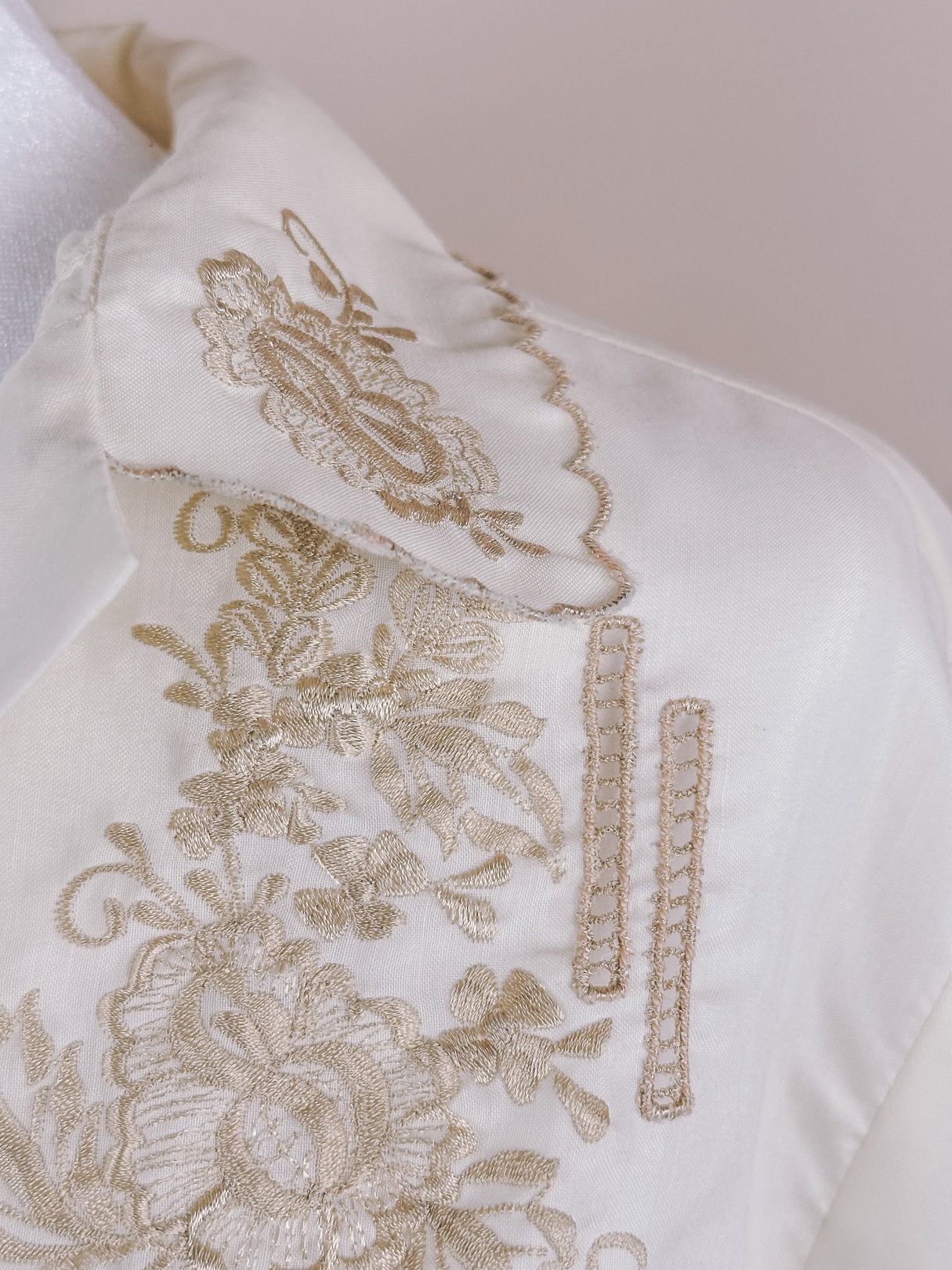Cream 1950s women's blouse featuring hand-embroidered scalloped details and floral patterns.