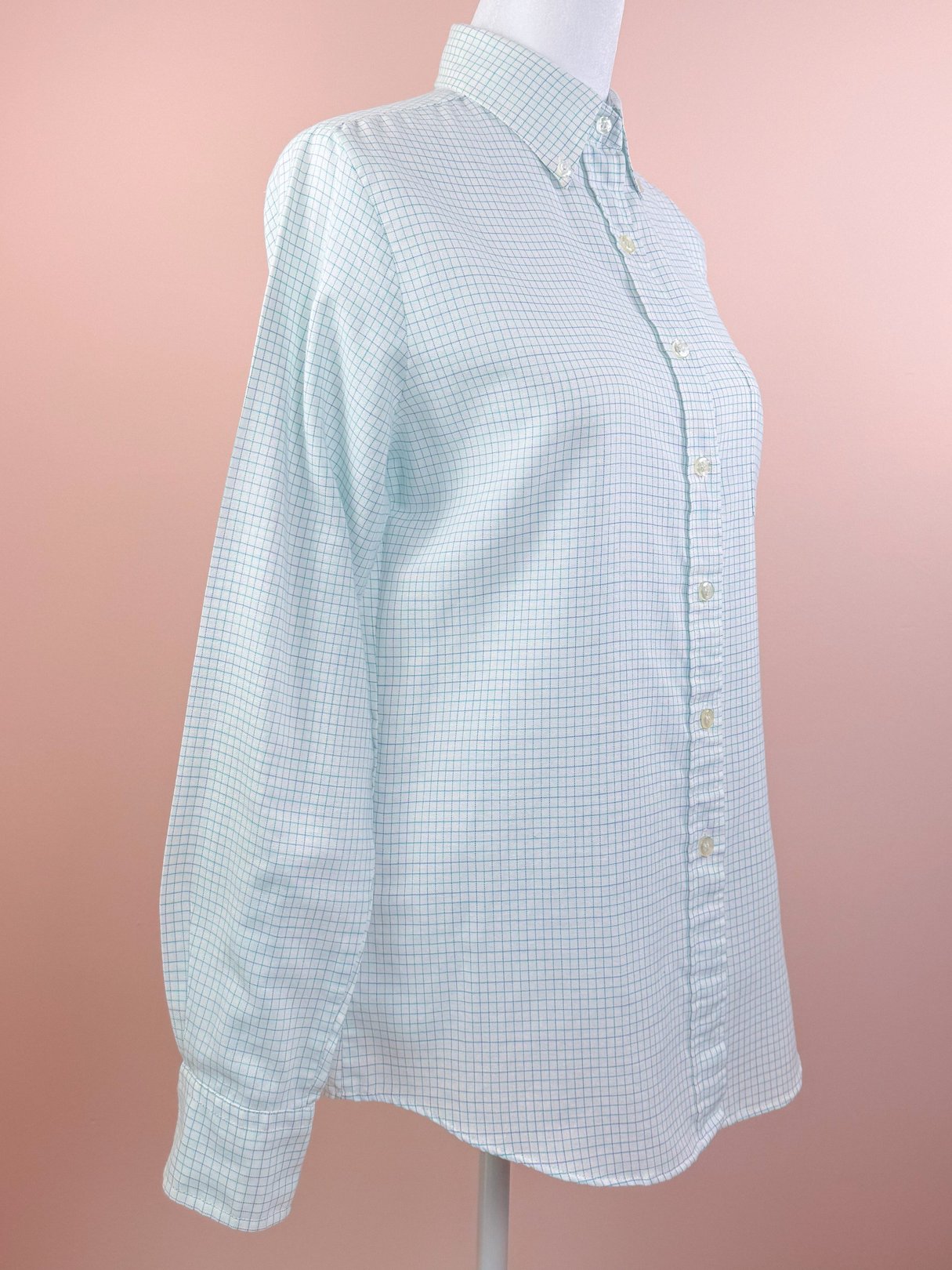 White preppy checkered button down shirt for women, featuring a classic collar and long sleeves, styled in a 1980s design.