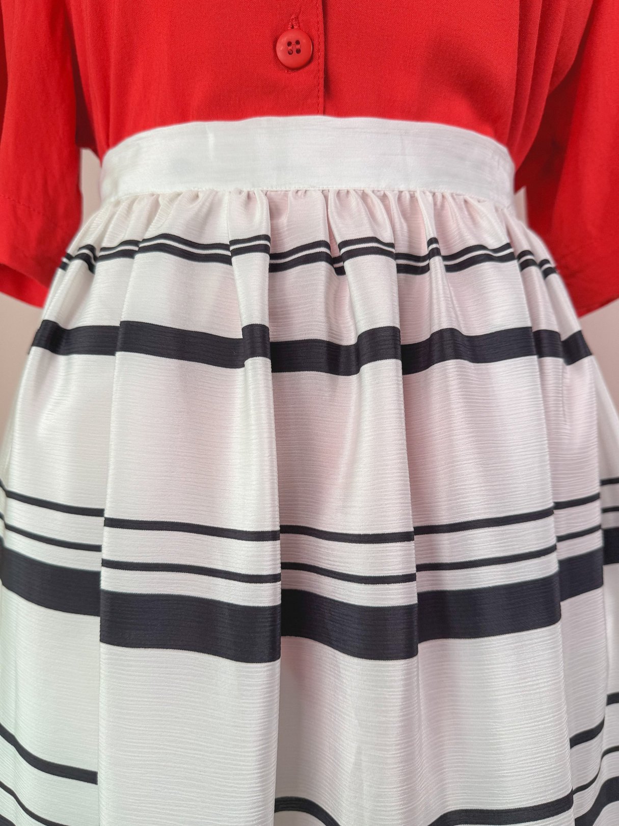 White skirt with black stripes and a fitted waistband, typical of 1970s women's fashion.
