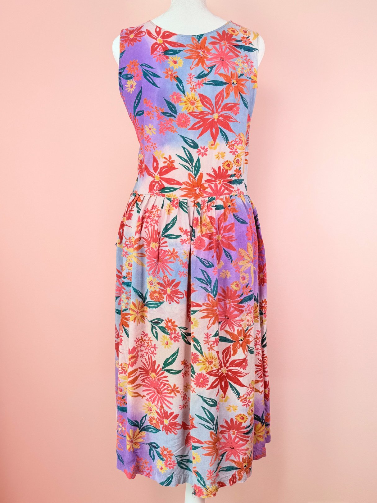 A pink and multicolored floral dress from the 1990s, featuring a sleeveless design and a mid-length skirt.