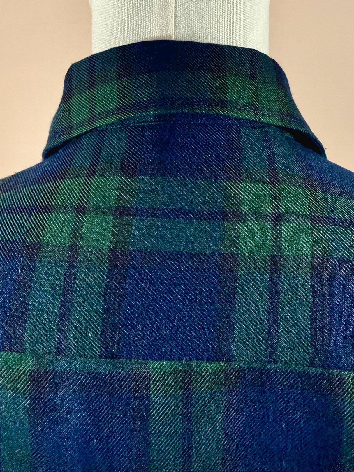Navy blue plaid shirt with green accents, featuring a classic collar and 1950s styling.