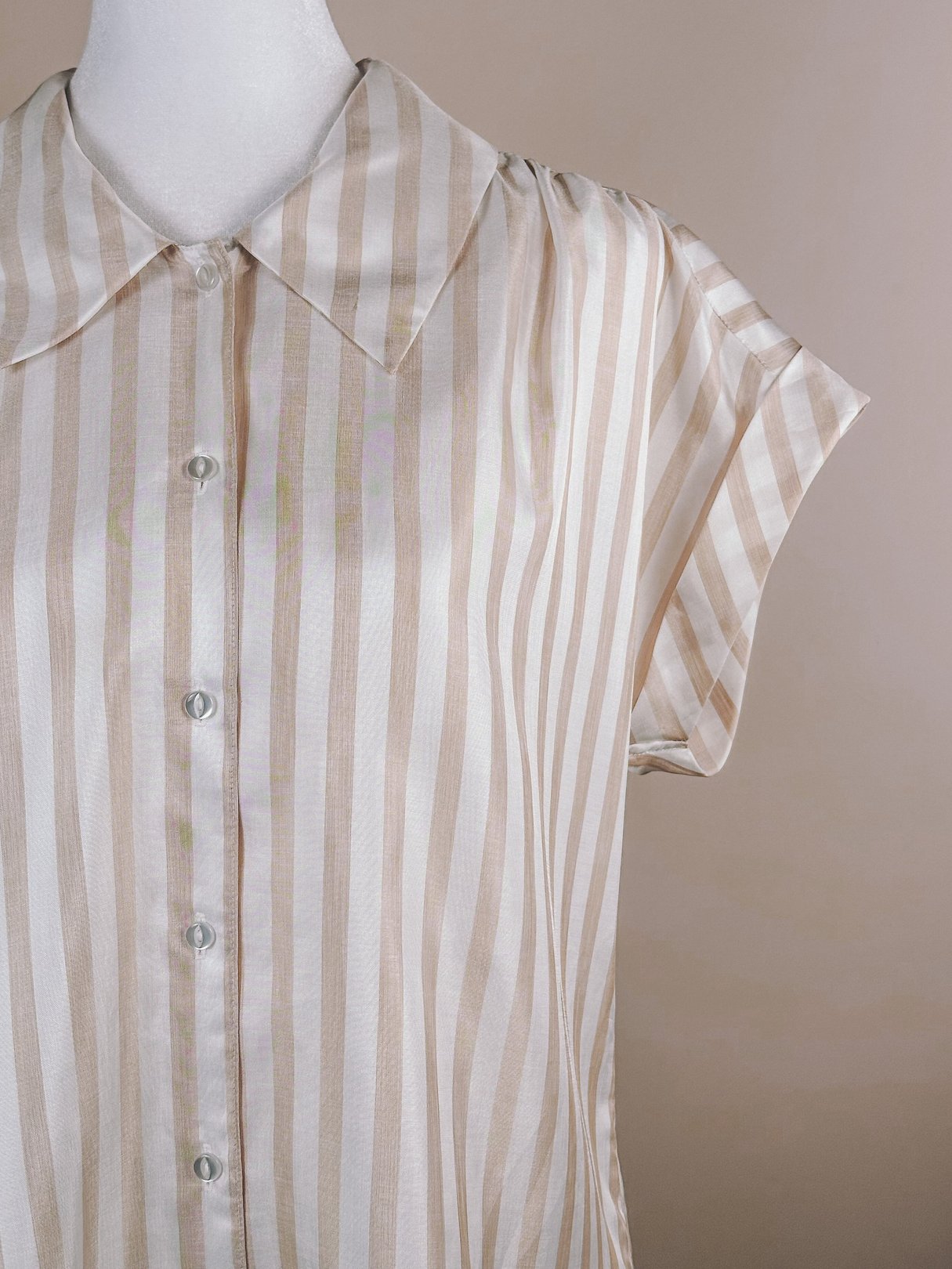 1970s women's striped blouse in white with tan and blush stripes, featuring a classic collar and short sleeves.