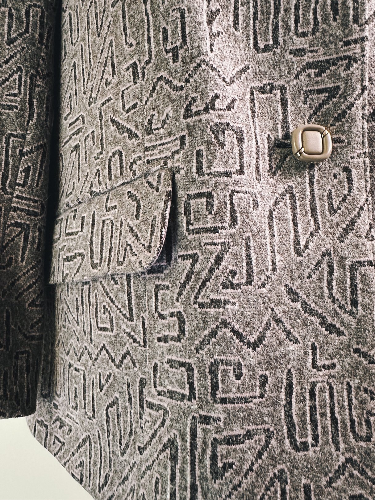 1980s women's pink geometric blazer featuring a patterned fabric and a single button closure.