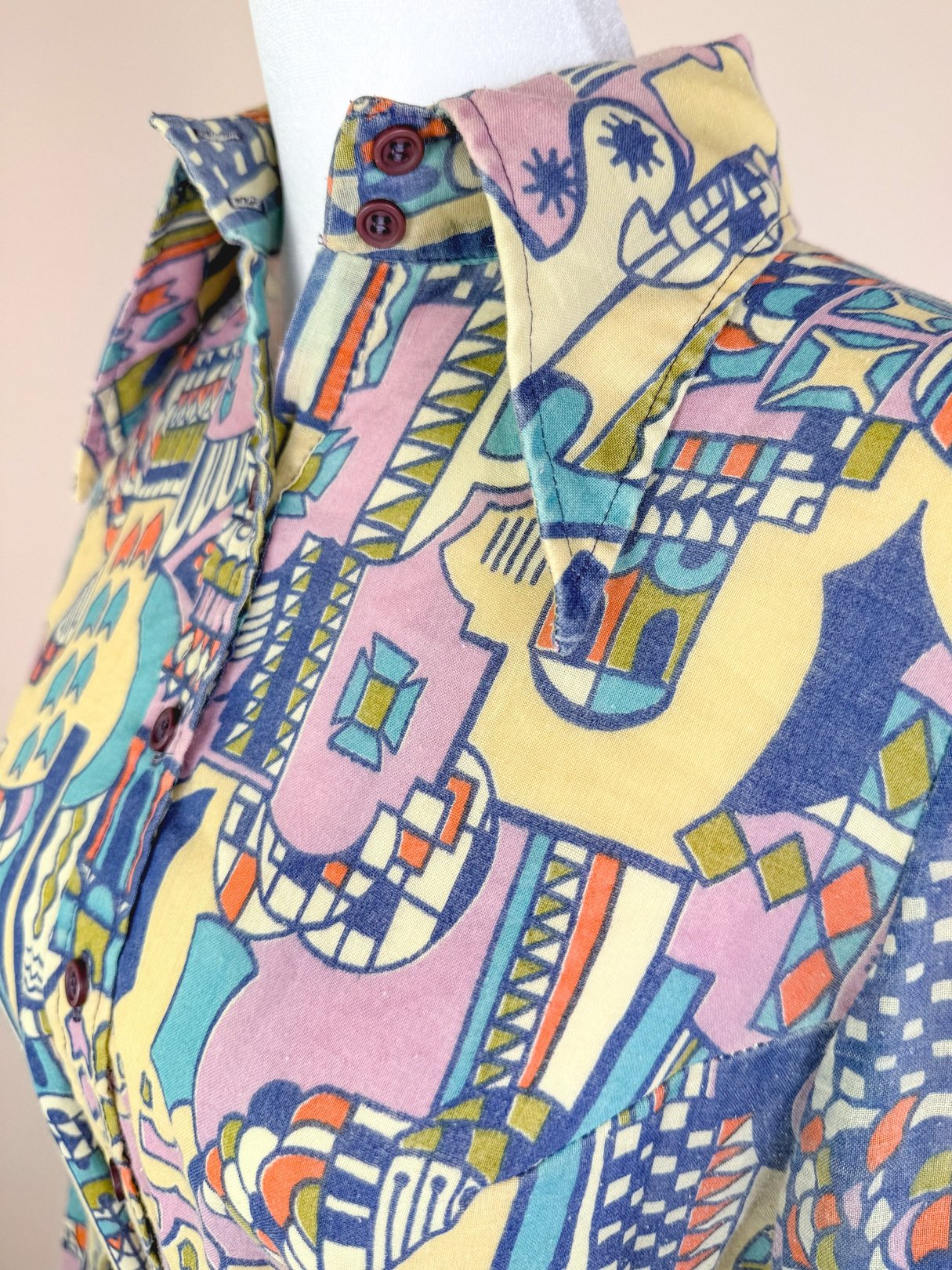Cream 1970s Metropolis Dress featuring a colorful abstract pattern, button-up collar, and short sleeves designed for women.