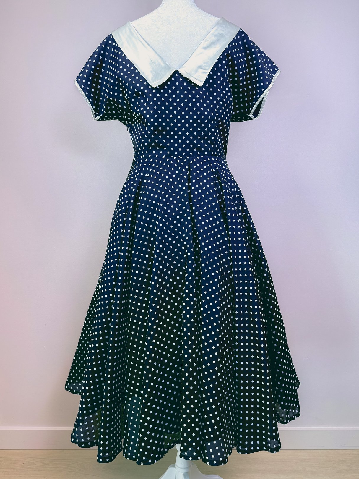 Navy blue 1950s El Raval Dots Dress featuring a white collar and polka dot pattern, with a flared skirt.