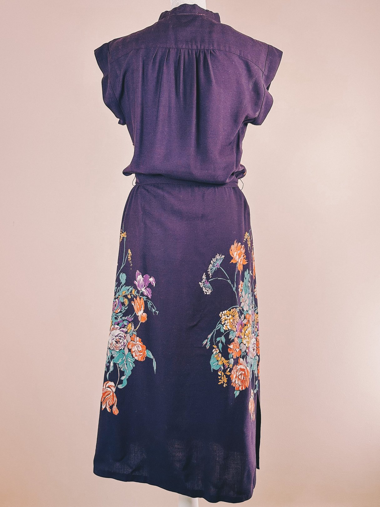 Purple 1970s women's dress featuring floral embroidery on the skirt and a short-sleeve design.