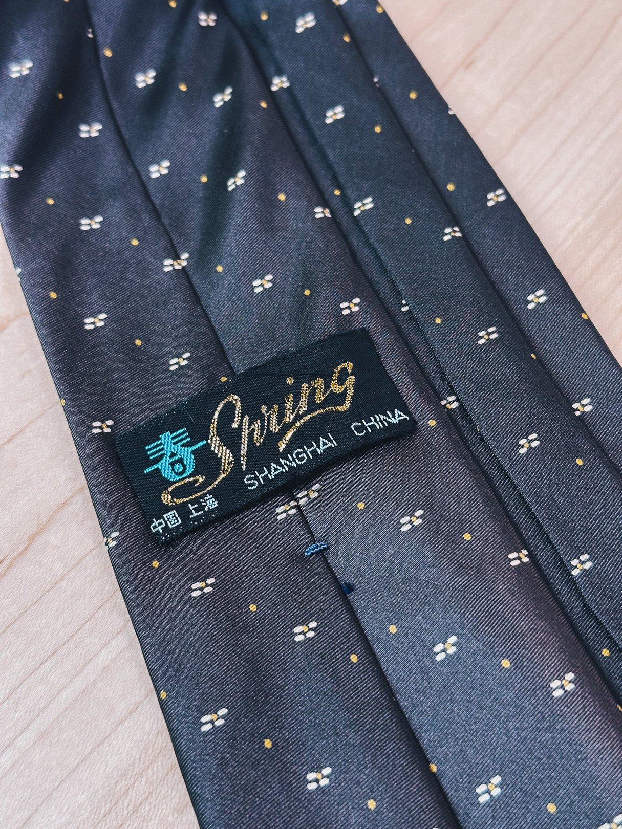 Brown tie featuring yellow dot patterns, labeled with "Shring Shanghai China," reflecting a 1970s accessory style for women.