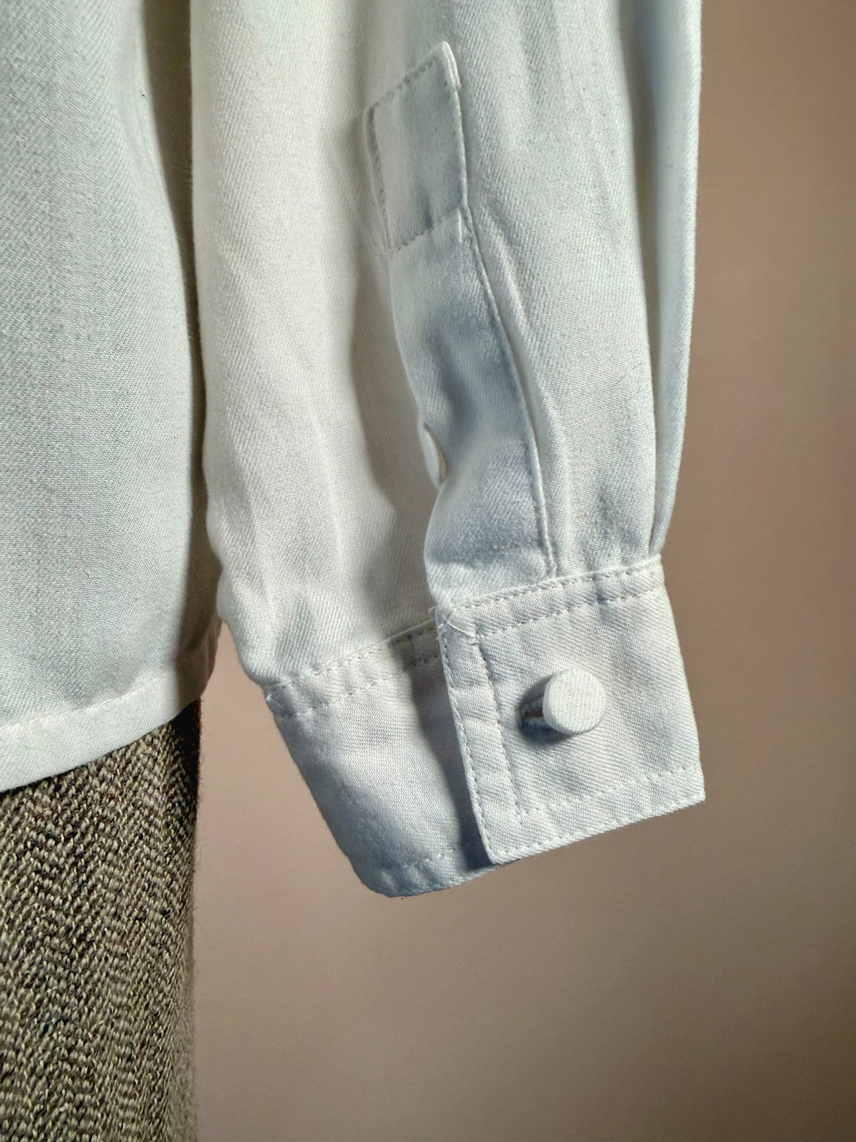 White cotton shirt with embroidered details and buttoned cuff, styled for women in the 1970s.