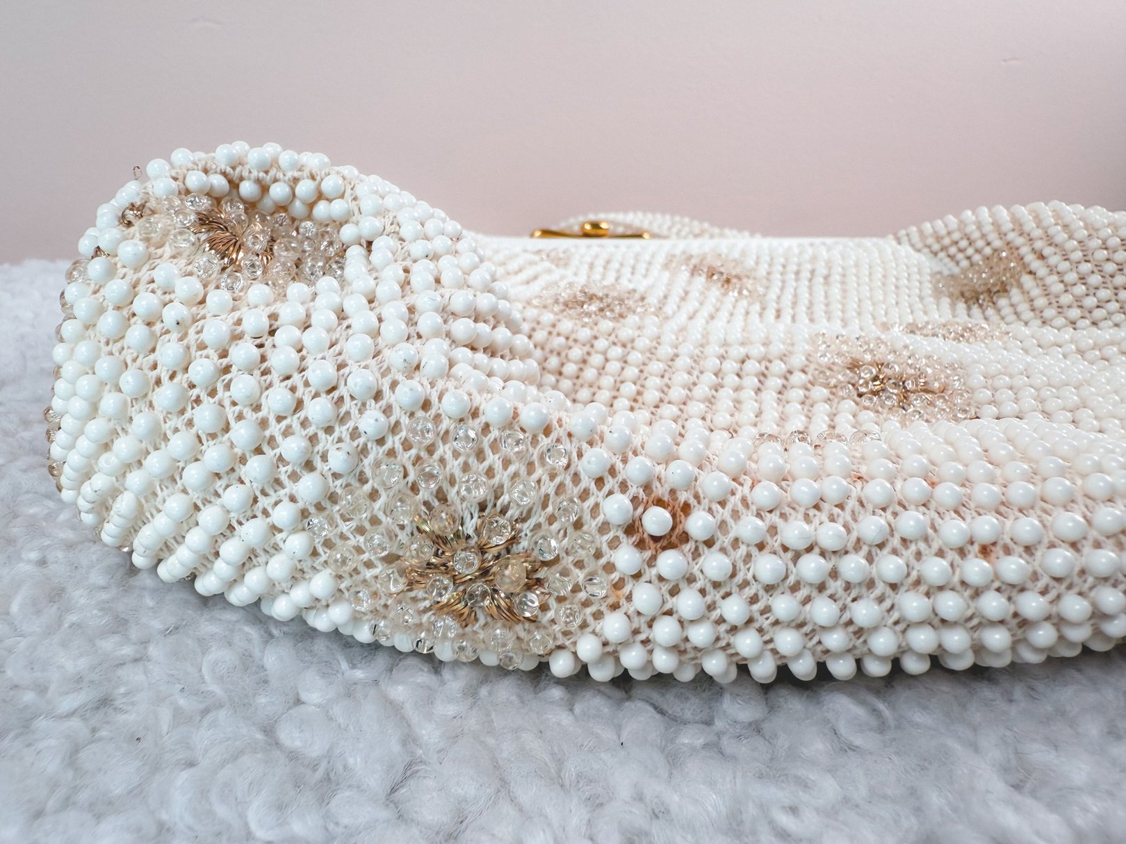 Cream white handbag adorned with intricate beadwork and embellishments, reflecting a 1950s style suitable for women.