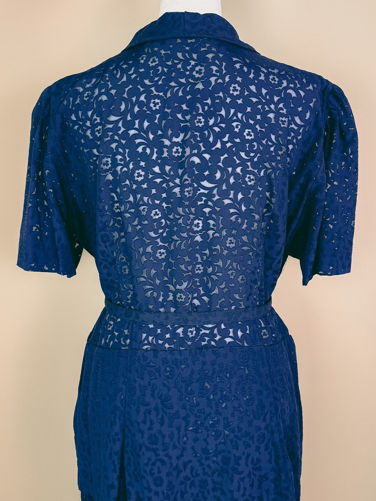 Navy blue 1940s women's French Café Dress featuring a floral cutout design and short puffed sleeves.