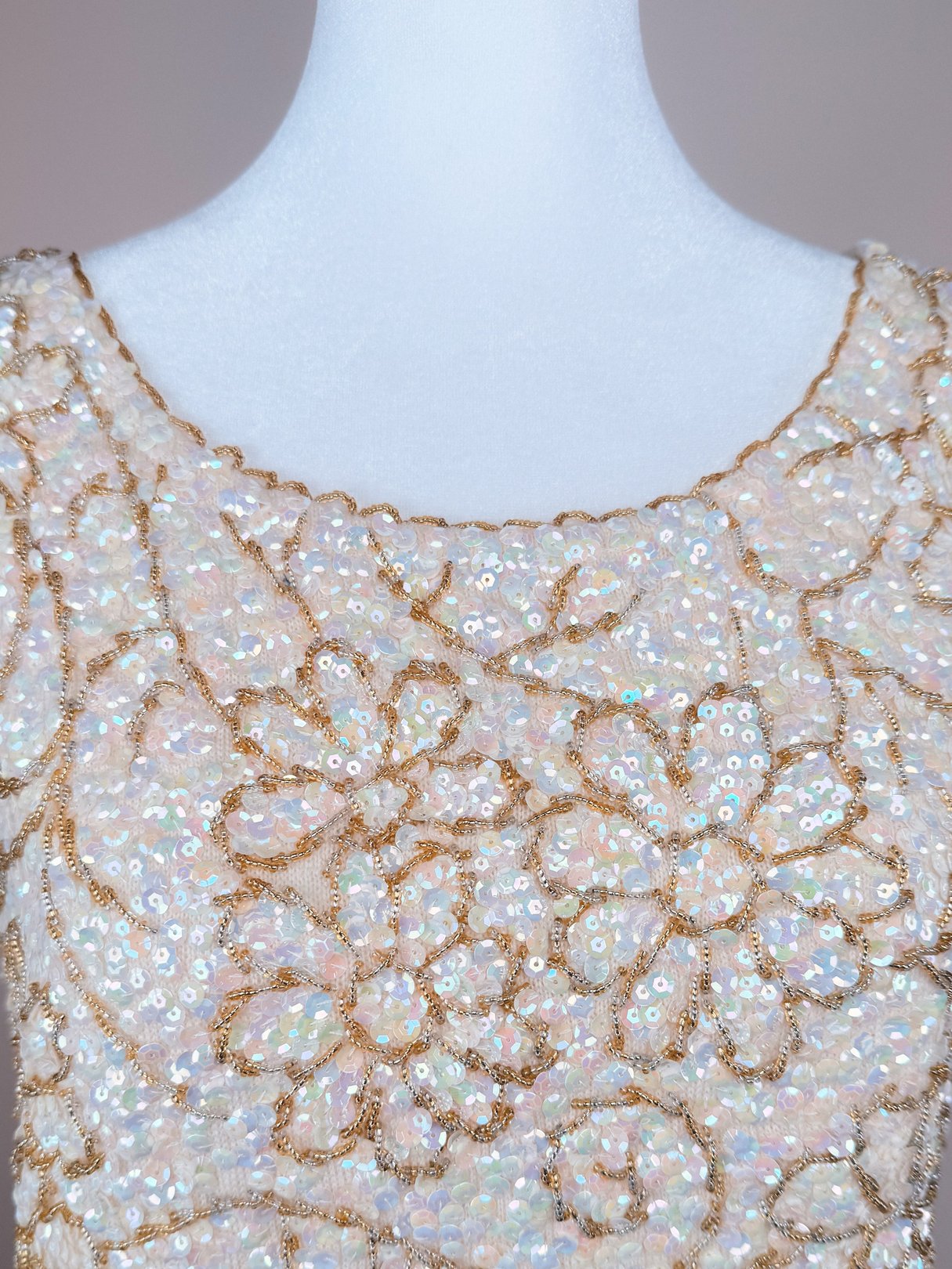 White 1960s women's Champagne Blossom Top featuring a floral design with sparkling sequins and gold threading.