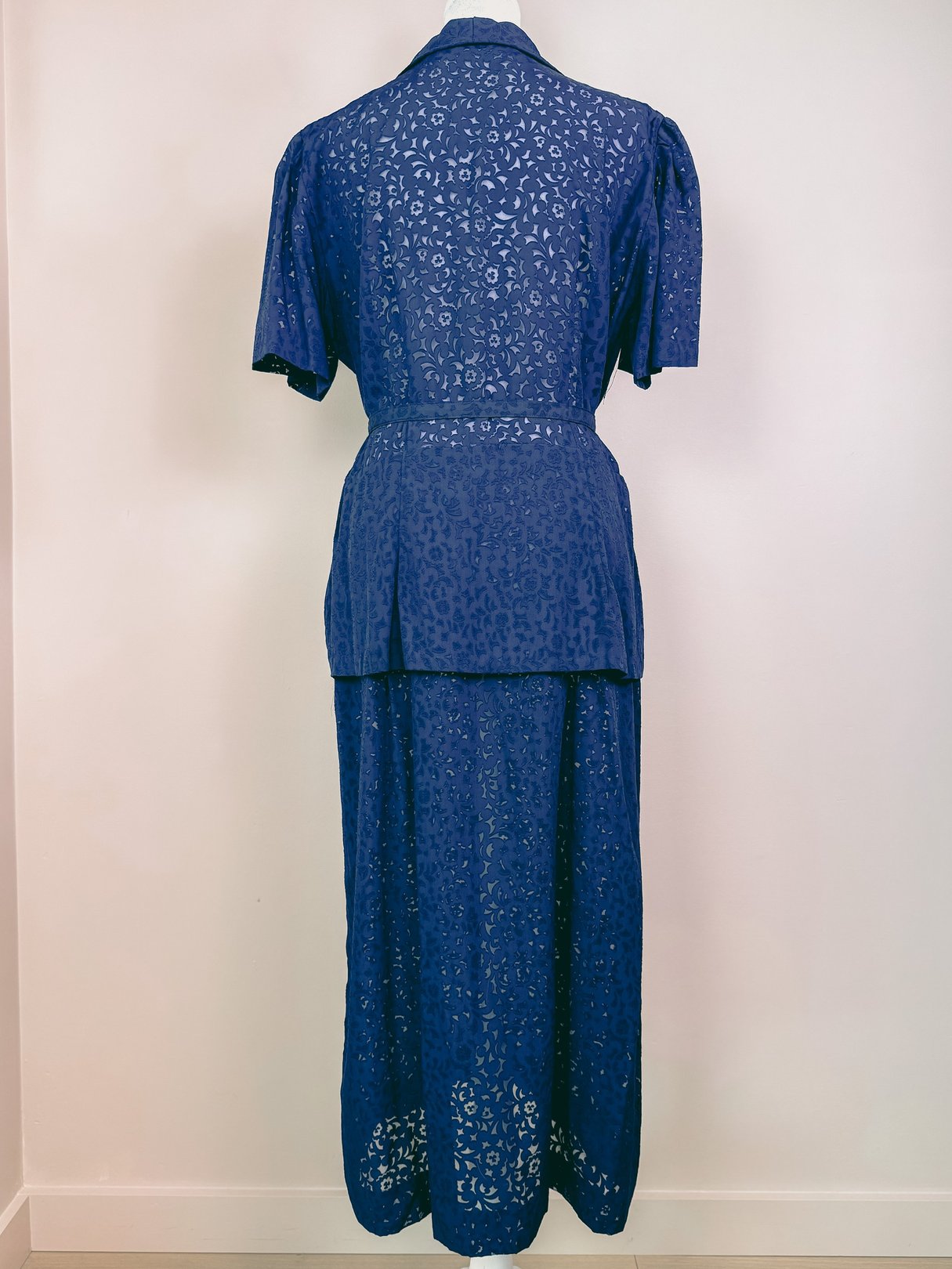 Navy blue 1940s women's French Café dress featuring a short-sleeved, fitted bodice and a long, flowing skirt.