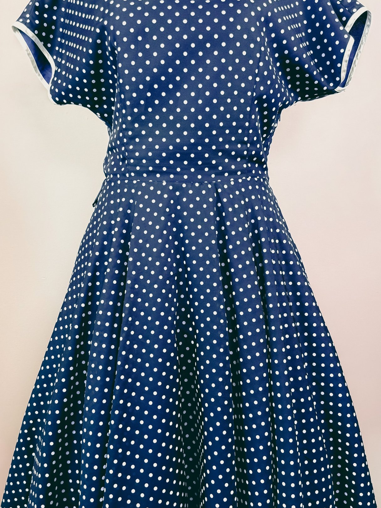 Navy blue 1950s-inspired dress with a polka dot pattern and a flared skirt.
