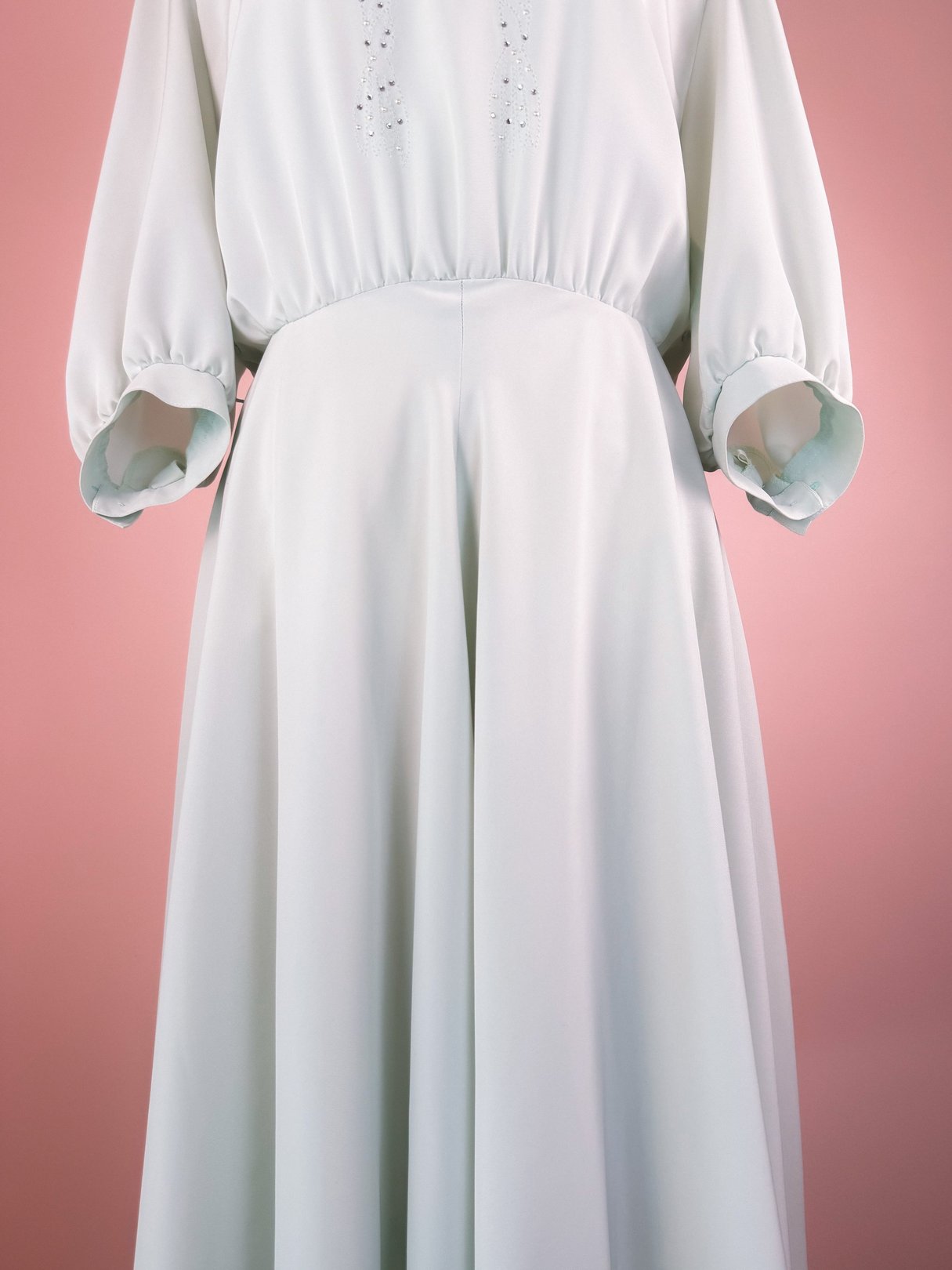 A mint green 1980s women’s dress with puffed sleeves and a gathered waist, featuring sparkle embellishments.