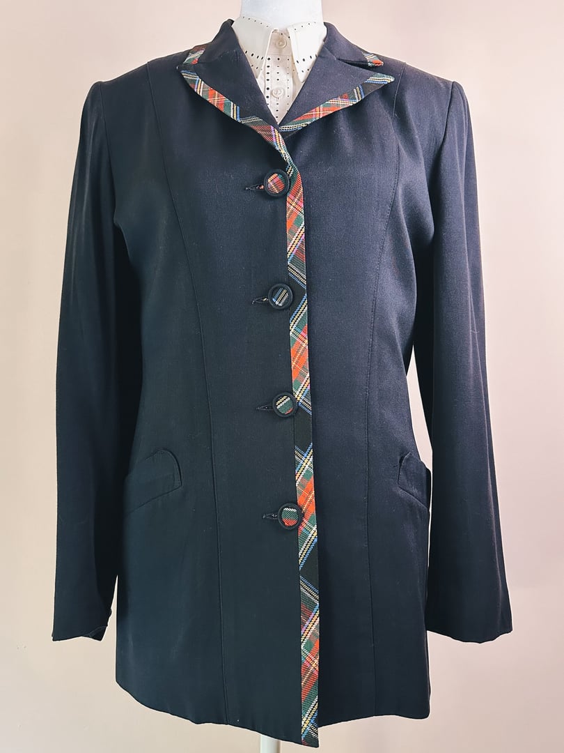 Black plaid suit jacket with a tartan pattern trim and button front, designed for women in the 1990s.