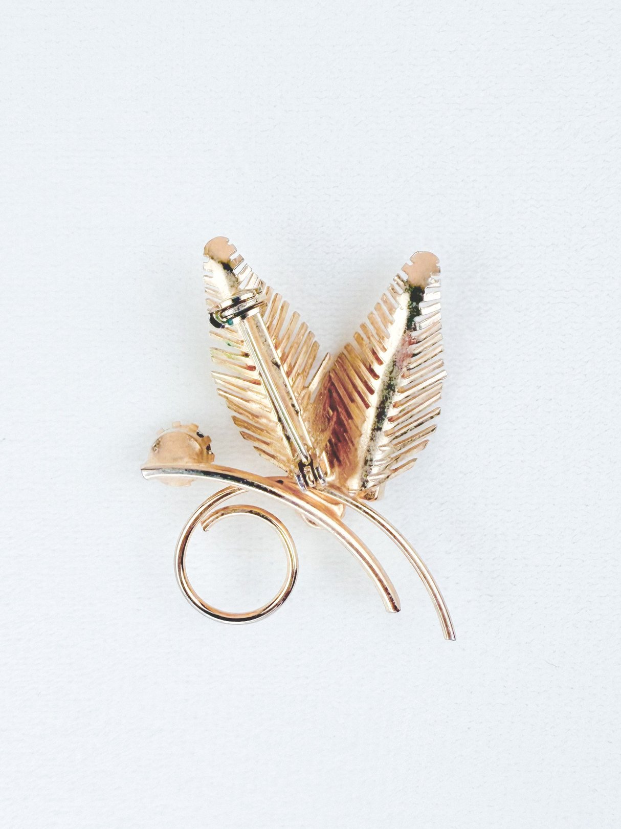 Gold tone 1950s Gilded Fern Brooch featuring layered fern leaves and a swirl design.