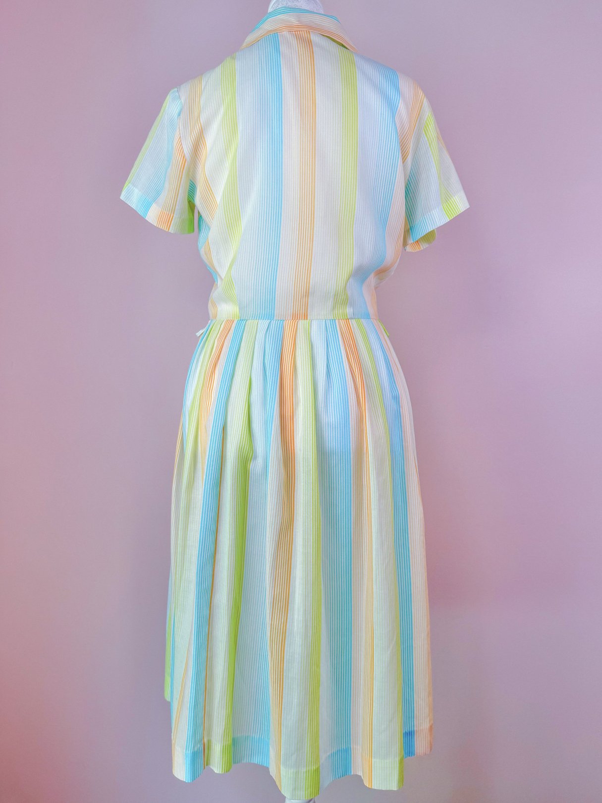 1950s women's Citrus Dress featuring vertical stripes in orange, yellow, and green, with a fitted waist and flared skirt.