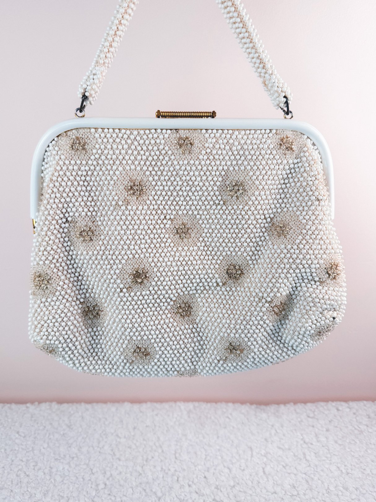 Cream white 1950s handbag adorned with sparkling embellishments and a structured frame.