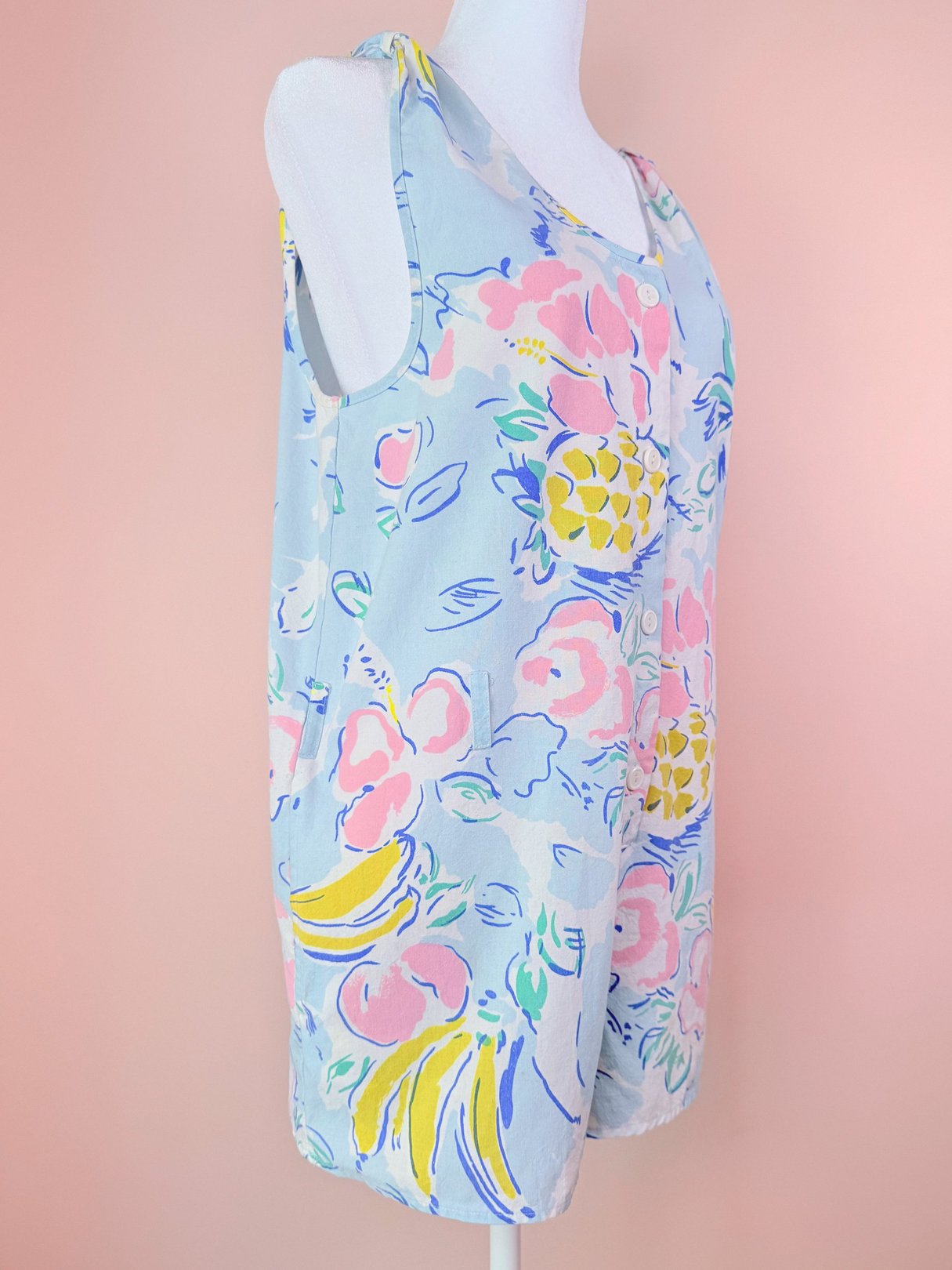 Light blue women's romper featuring a tropical floral pattern with pineapples, reminiscent of 1980s fashion.