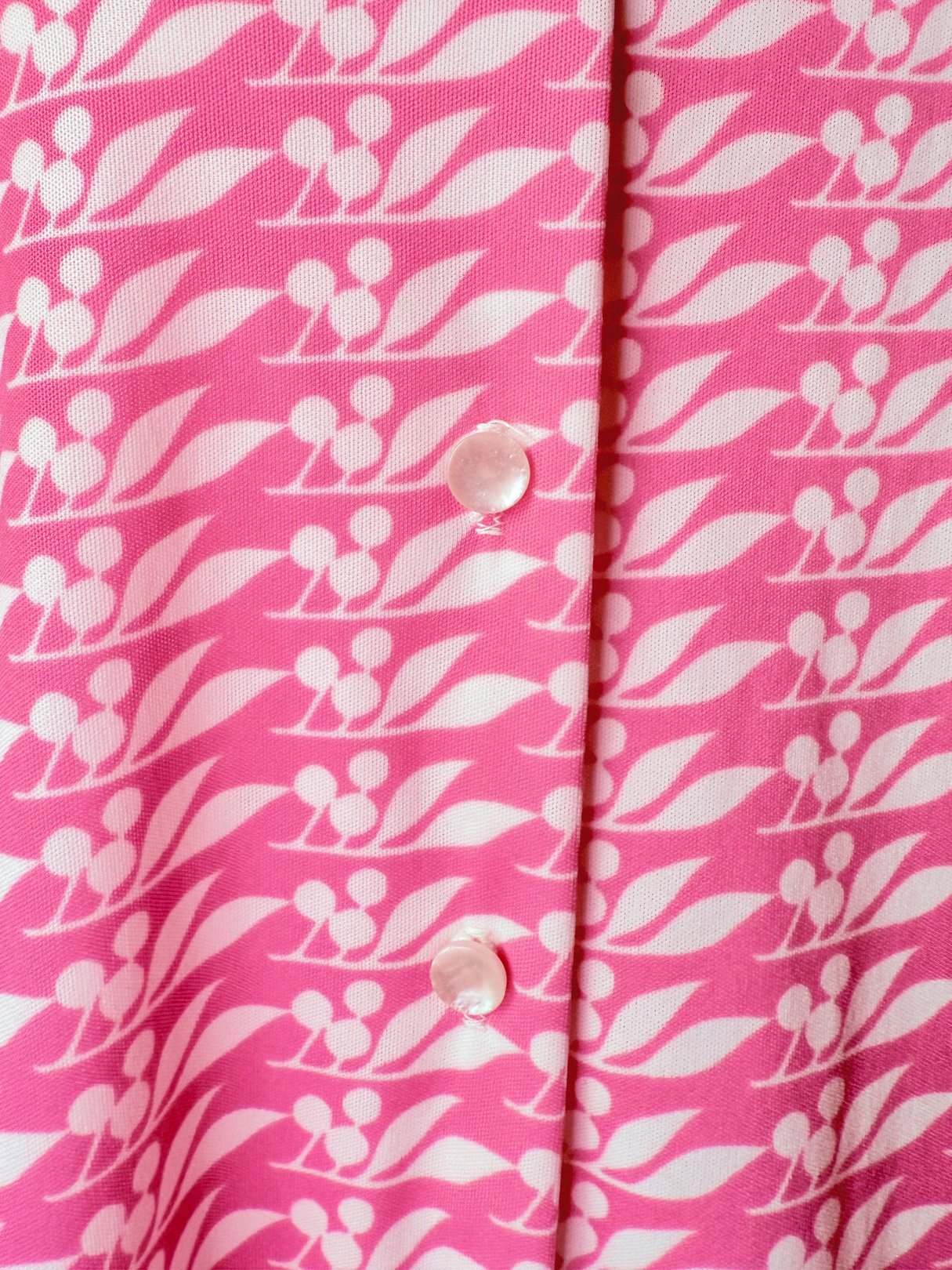 Pink blouse featuring a cherry petal pattern, button closure, and a 1970s style designed for women.