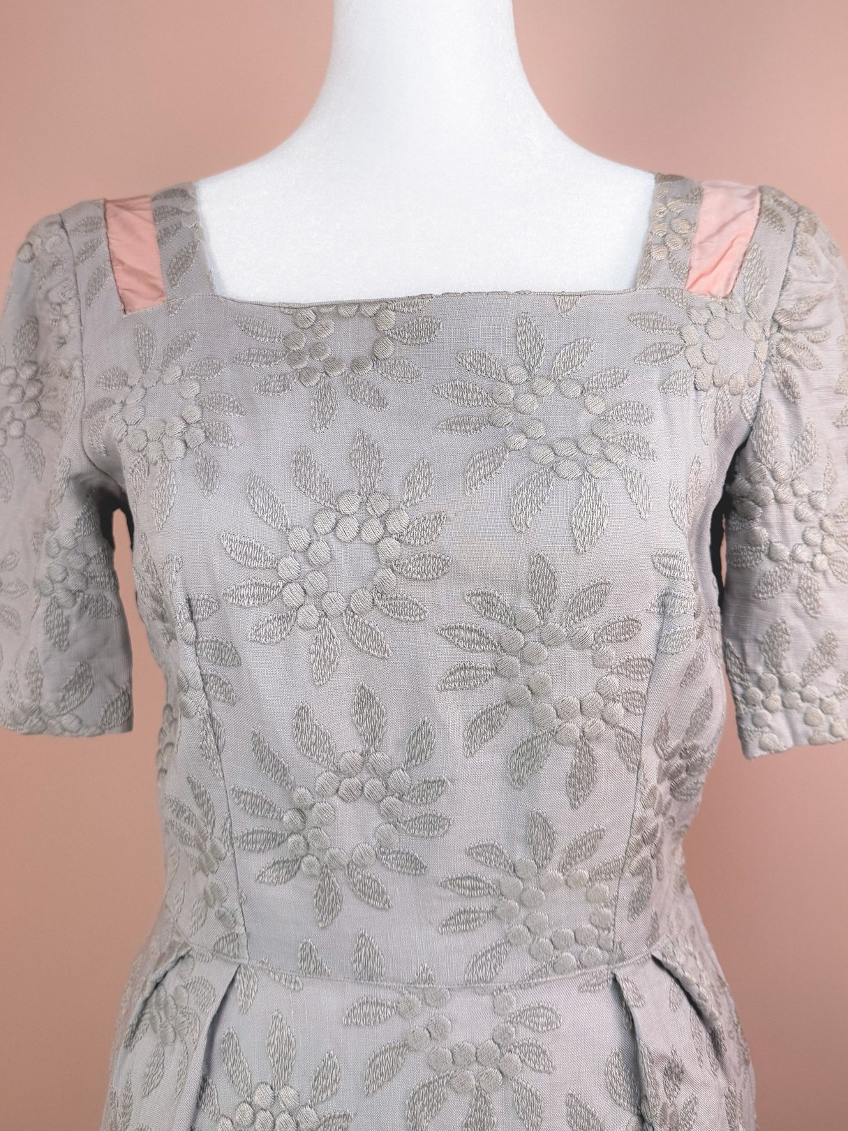 Slate blue 1950s women's dress featuring a floral embroidered pattern and satin details on the shoulder straps.