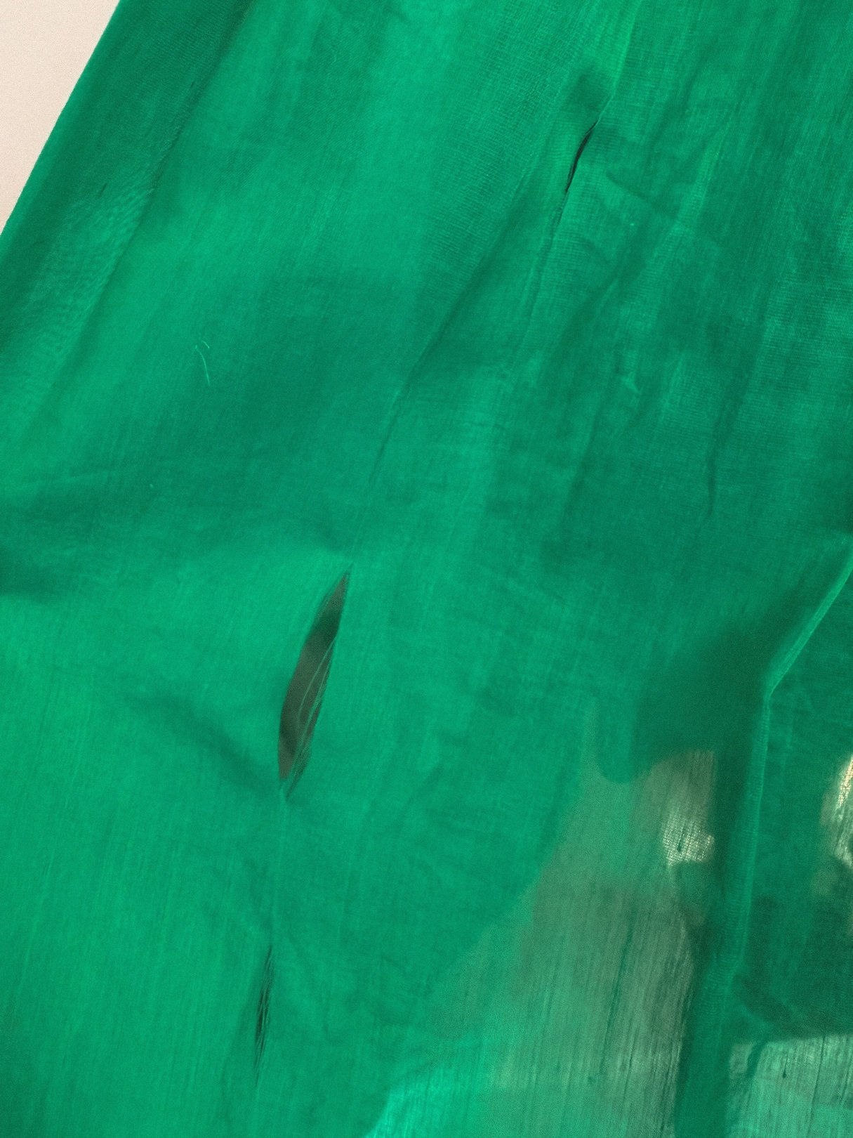 Emerald green fabric of a 1950s women's dress featuring a starburst design.