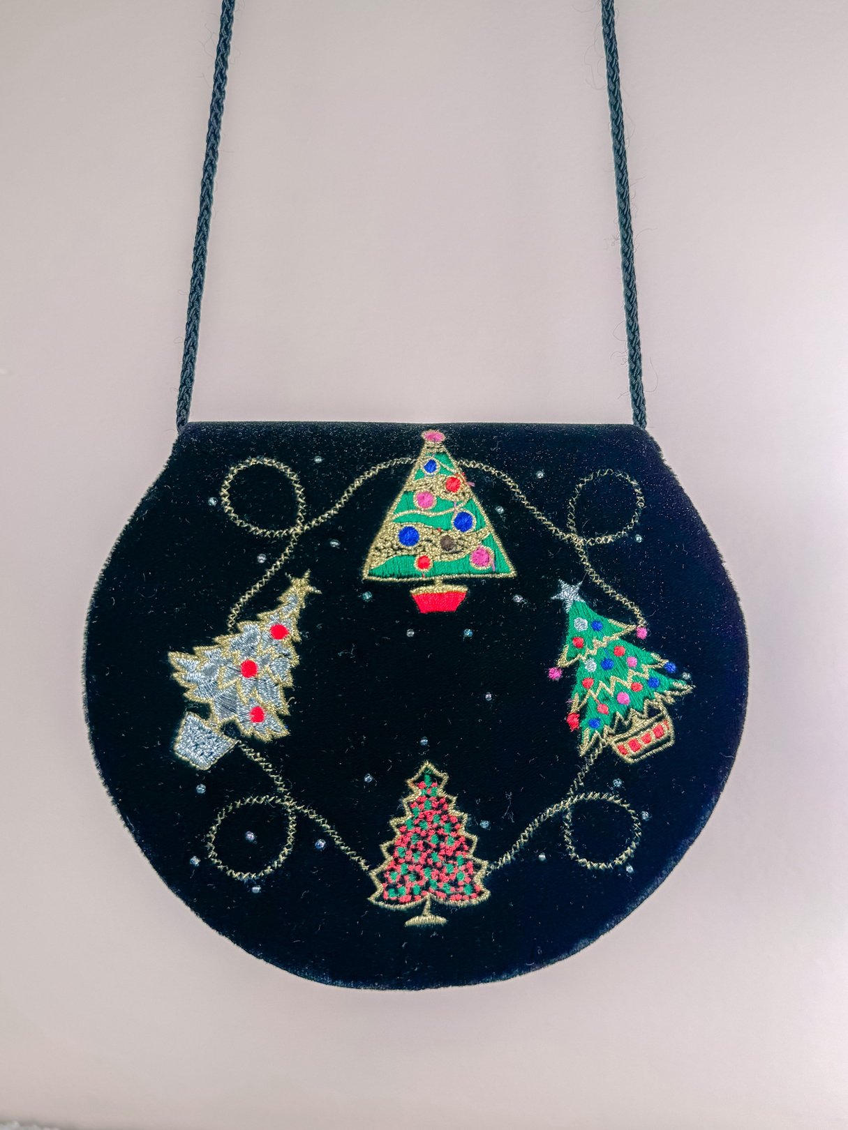 Black velvet purse featuring festive Christmas tree designs, embellished with colorful sequins, from the 1970s.