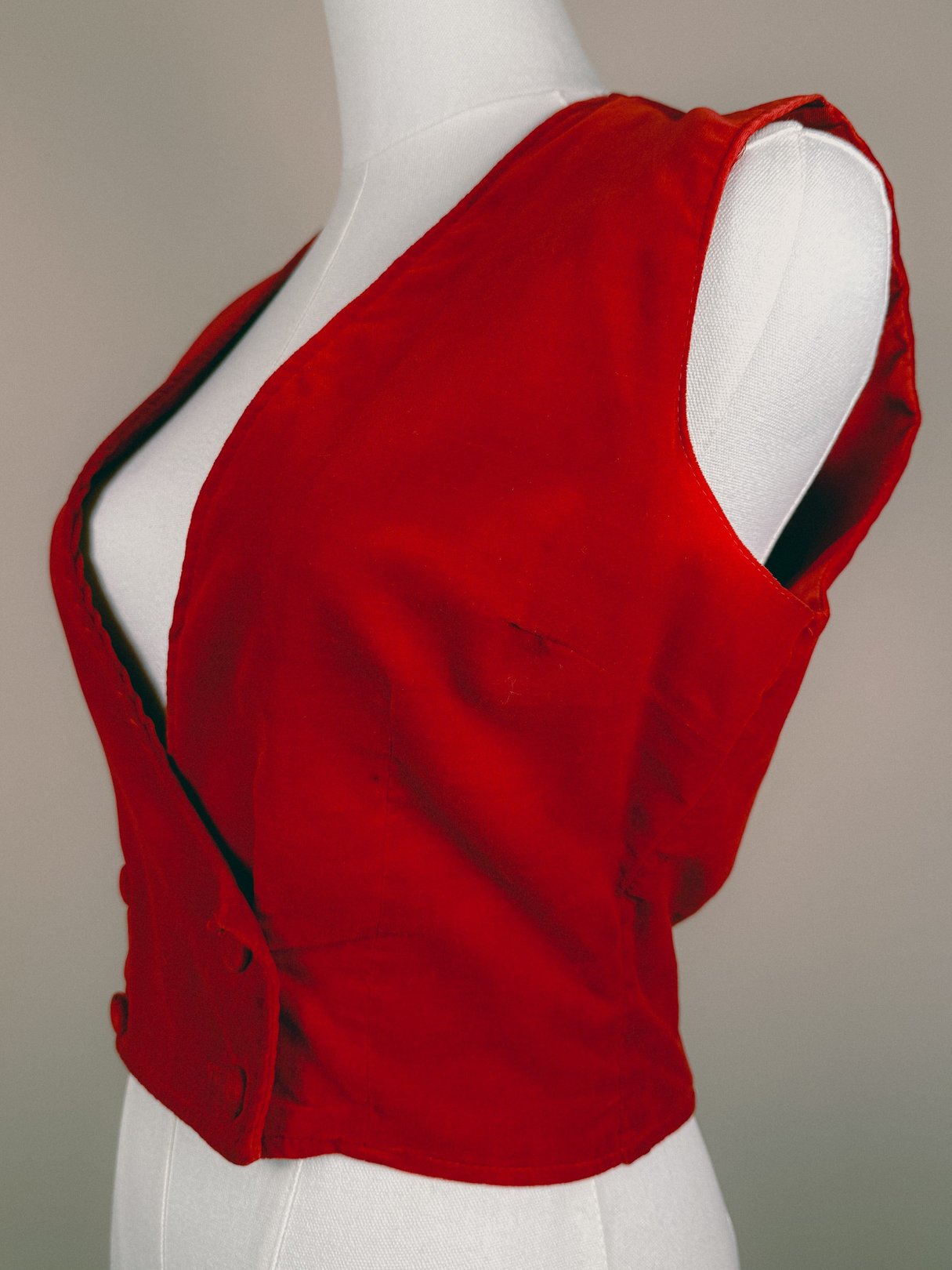 Red velvet mistletoe vest for women from the 1970s featuring a sleeveless design and a plunging neckline.