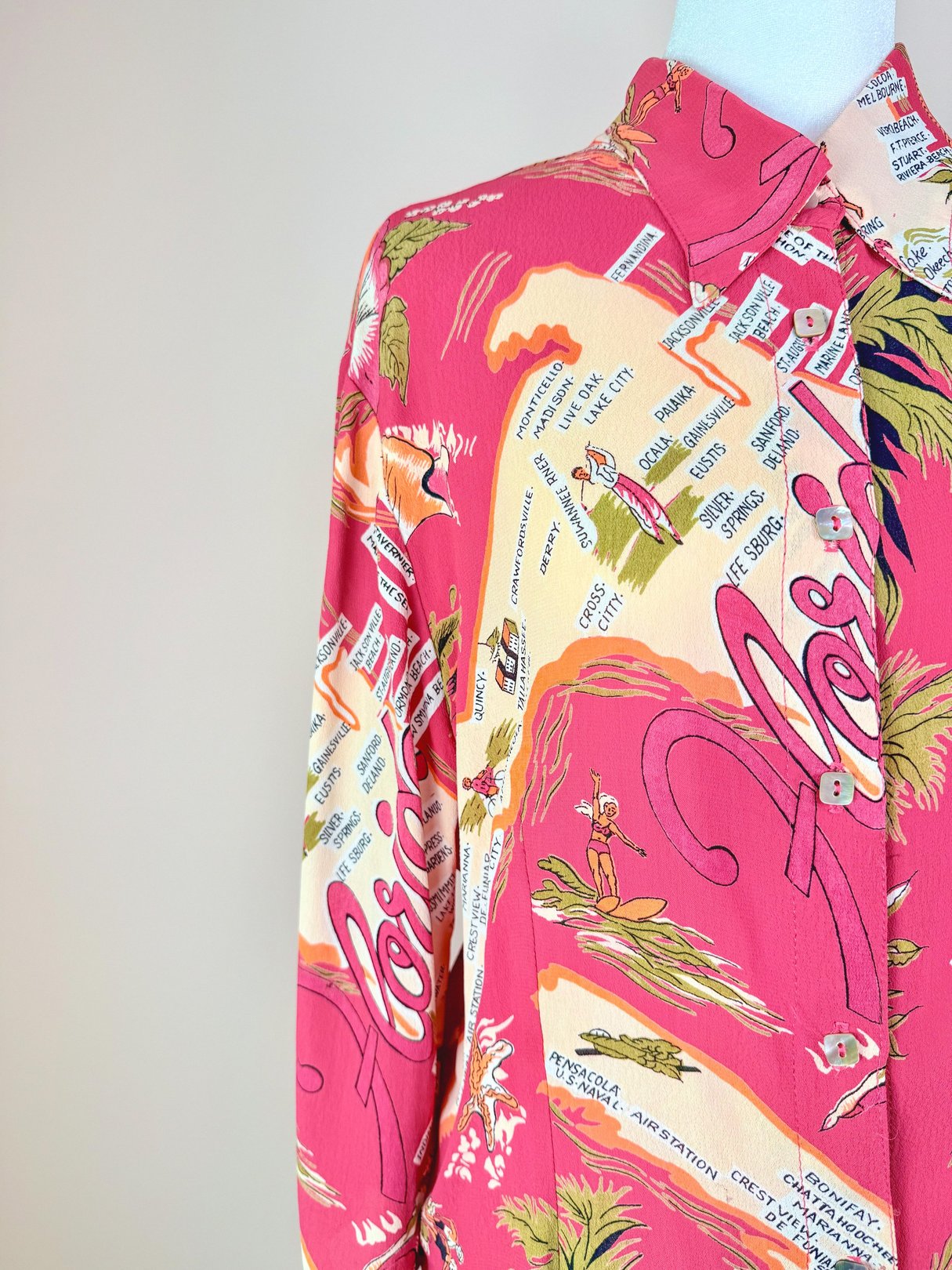 Women's 1970s white top featuring a vibrant pink floral and tropical print.