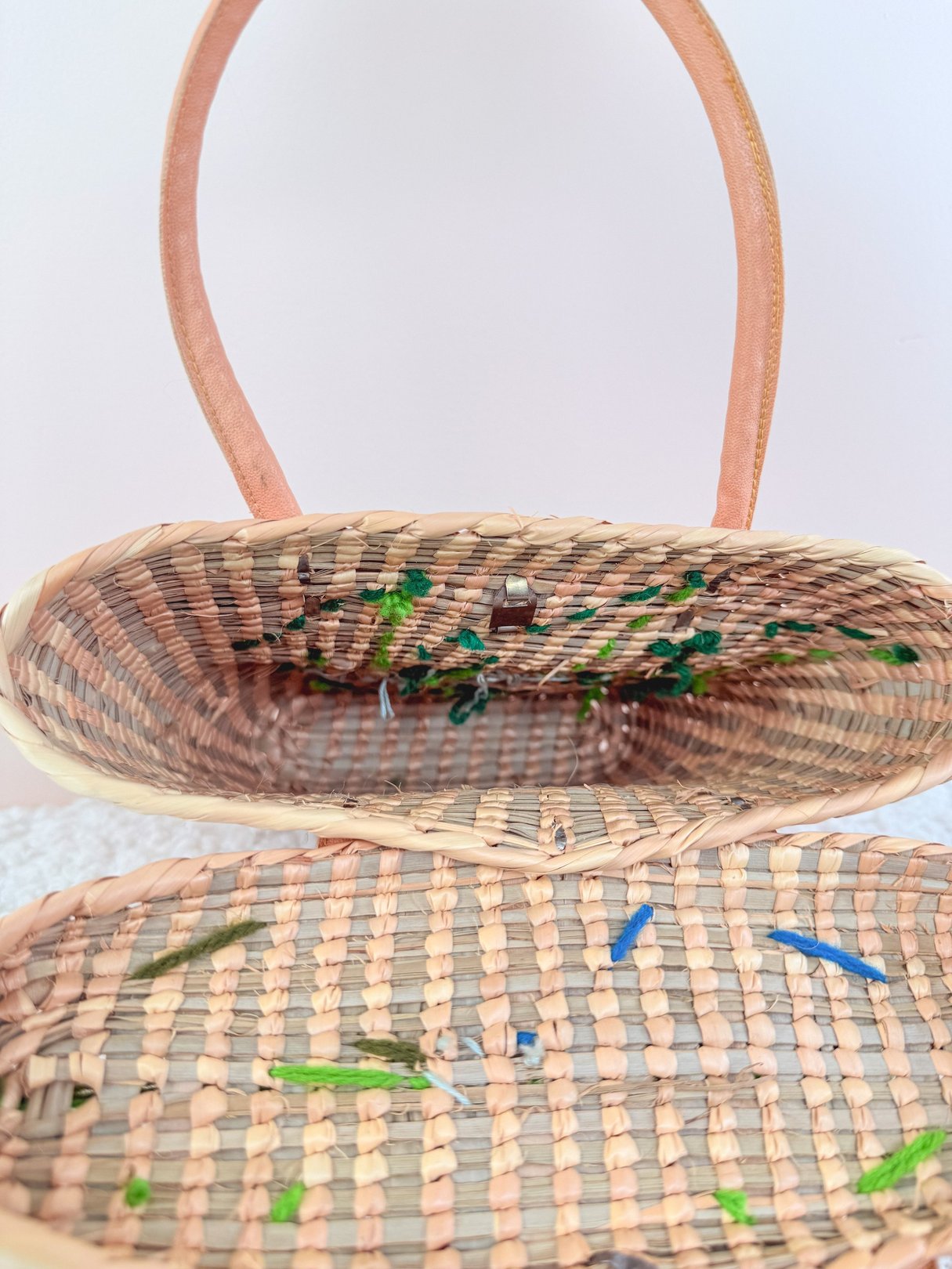 Blue straw handbag with a beige woven interior and leather handles, reflecting a 1970s style.