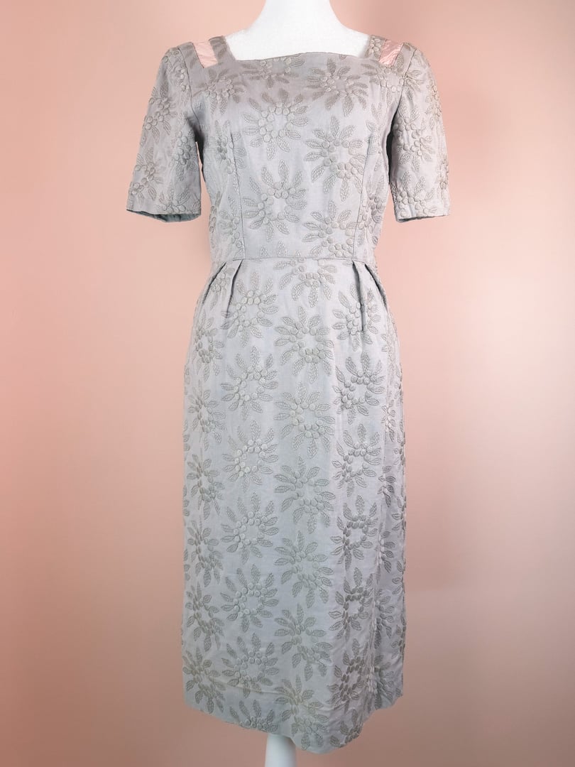 Slate blue 1950s women's dress featuring floral embroidery and short sleeves with satin bow details on the shoulders.