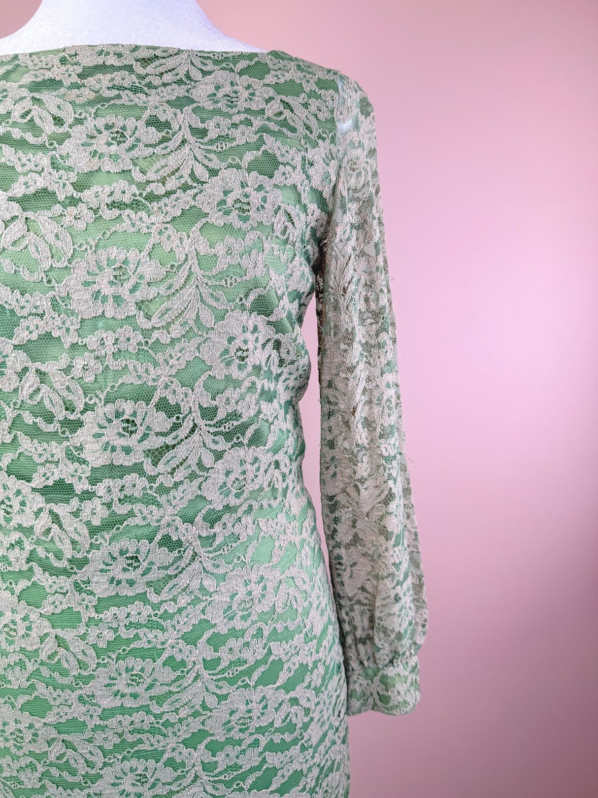 A 1960s women's dress in seafoam green featuring a textured lace design and long sleeves.