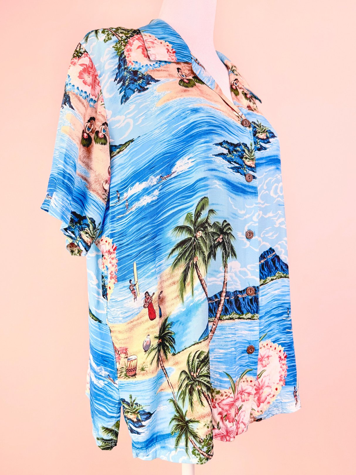 1960s women's blue Aloha Darling Top featuring a tropical print with palm trees and beach scenes.