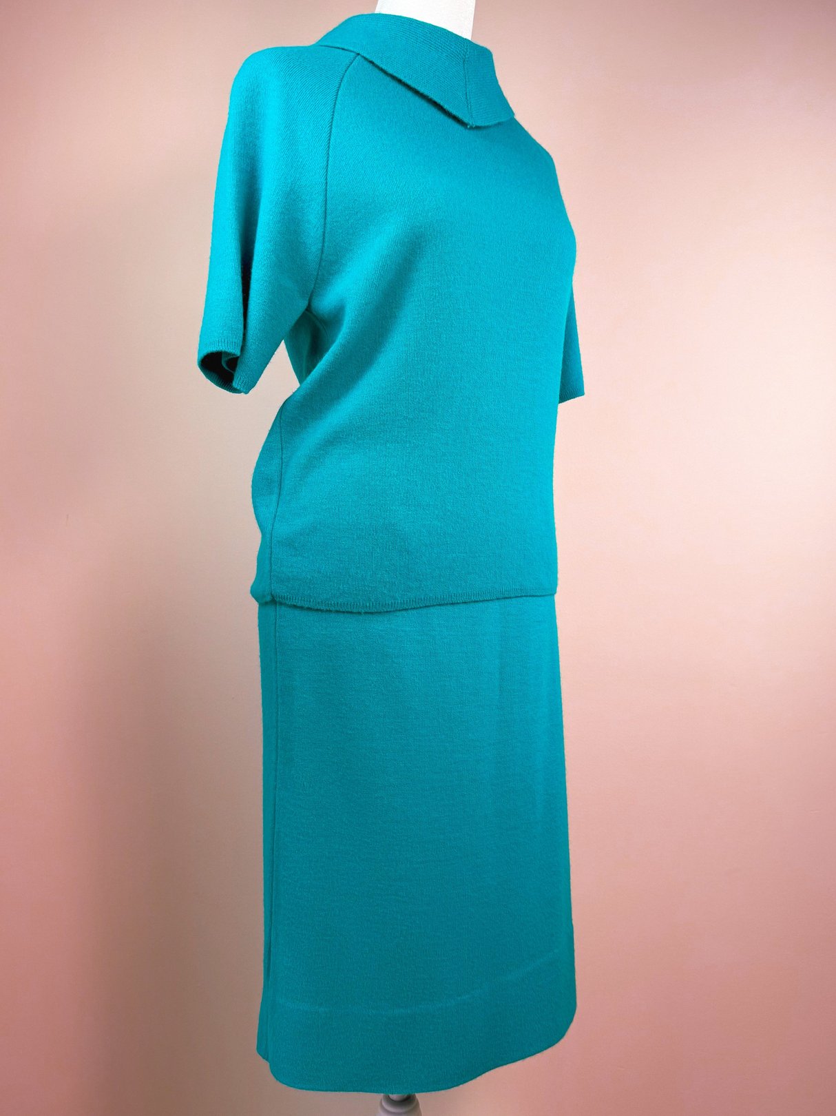 Teal green 1960s knit skirt set featuring a short-sleeve top with a soft collar and a matching knee-length skirt.