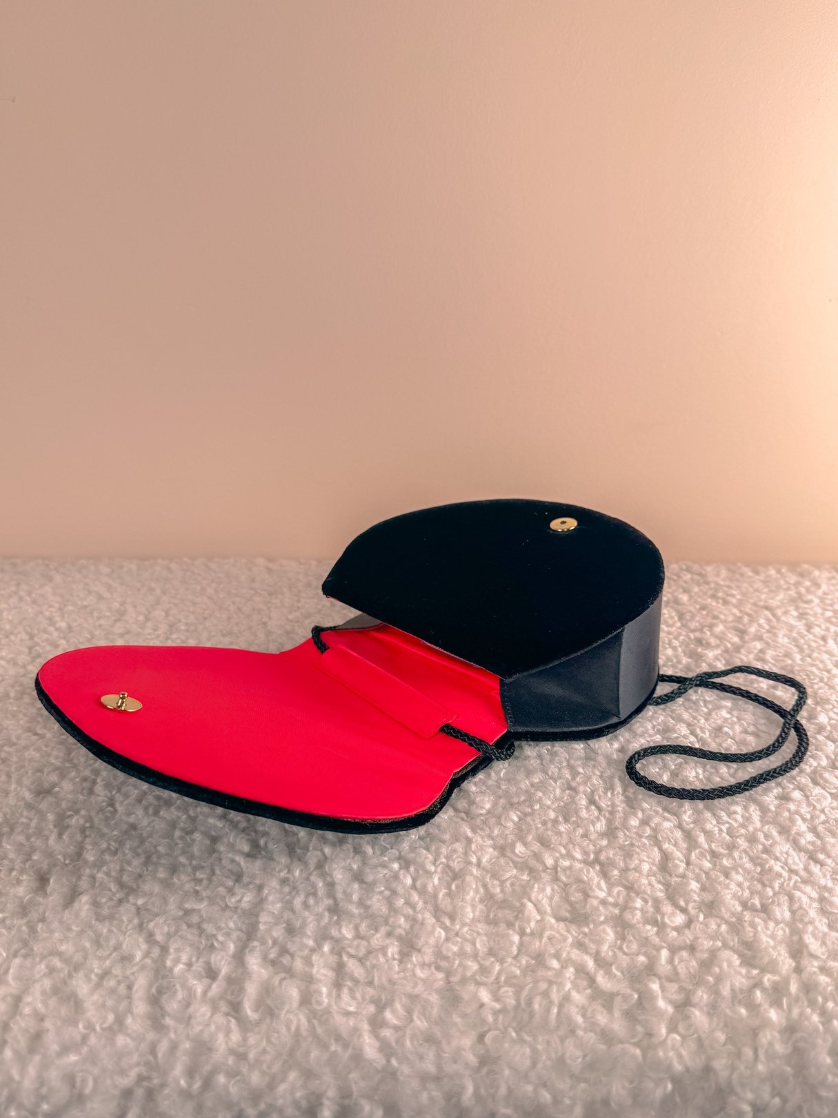 Black velvet purse with a red interior, featuring a chain strap and 1970s design details.