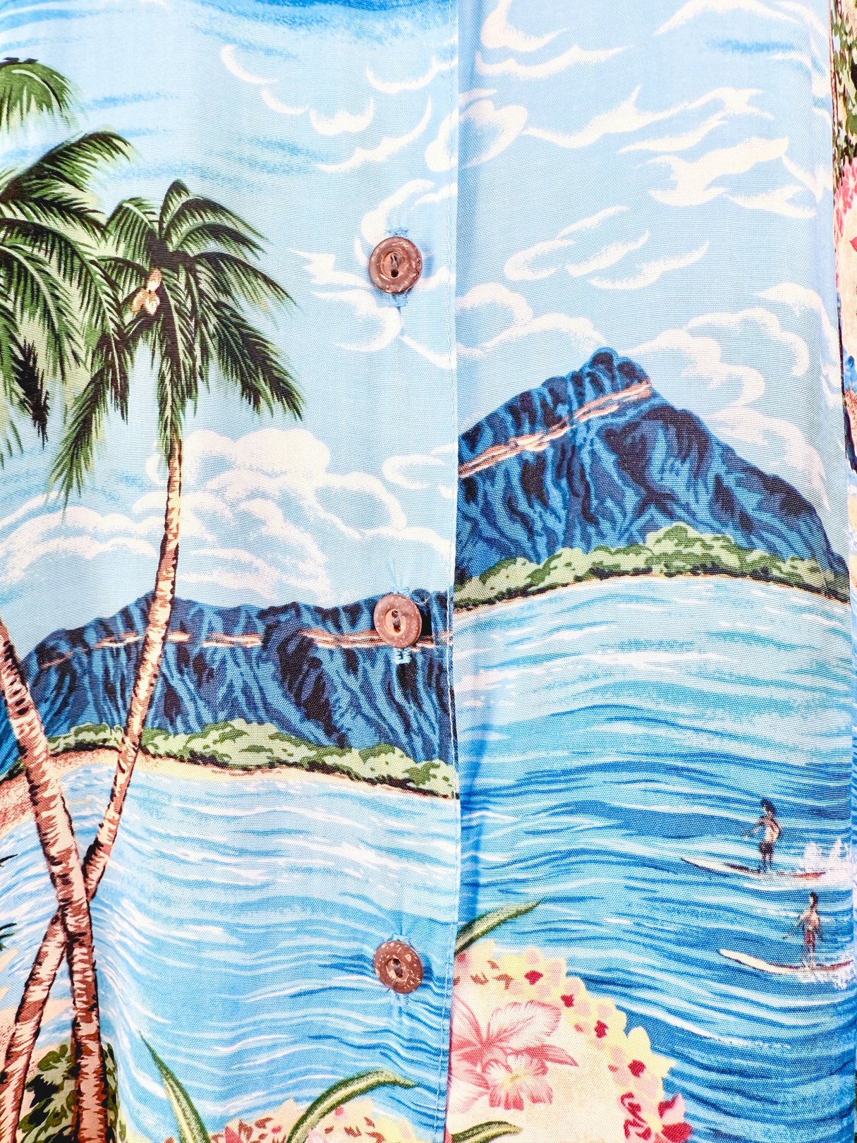 Blue 1960s women's Aloha Darling Top featuring a tropical print with palm trees and mountains.