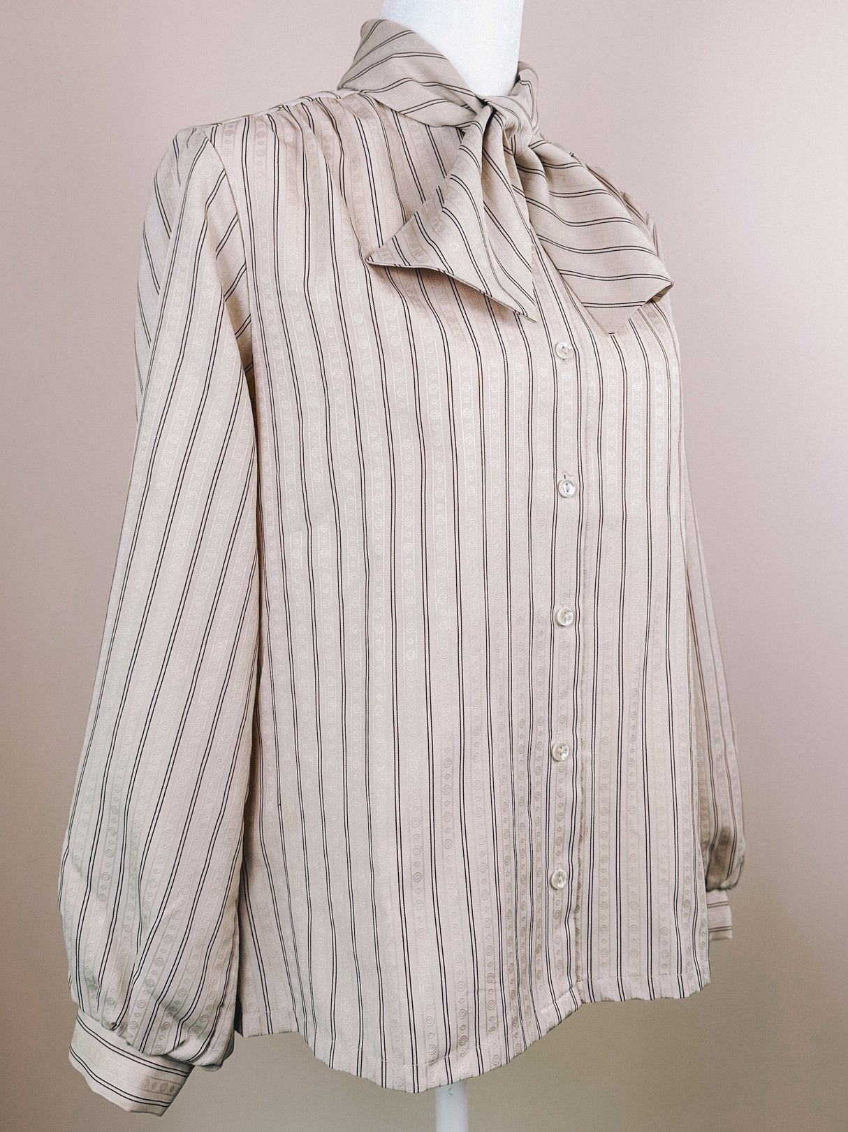 Maroon striped blouse with a bow tie collar, puffed long sleeves, and button-down front, suitable for women, reflecting 1980s style.